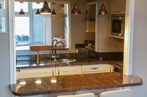 una cocina con fregadero y microondas en Seaview Apartment Sleeps 2 -Patio -WiFi -Tv, en Barmouth
