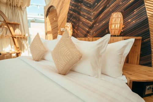 a bedroom with a bed with white pillows at Luxeglamp in Umm Al Quwain