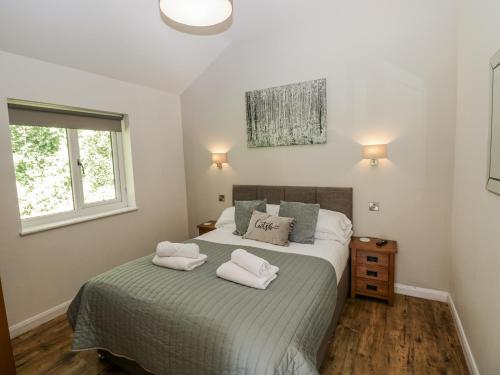 a bedroom with a bed with two towels on it at Dwrgi in Llanybyther