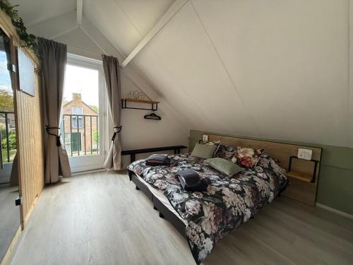 a bedroom with a bed and a large window at Pure Wellness Bungalows 121 Sauna&Massage&Hottub in Ewijk