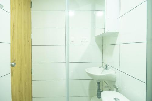 Un baño blanco con lavabo e inodoro. en Torre 811 By Jalo, en Cartagena de Indias