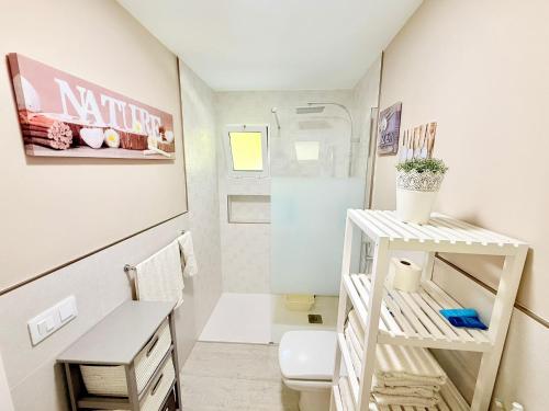 a small bathroom with a toilet and a sink at Maspalomas Garden Bungalow with BBQ in Maspalomas