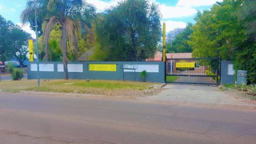 a gate on the side of a road next to a street at Eight Martjie Guesthouse in Brits