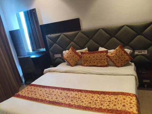 a bedroom with a large bed with pillows on it at AMRITSAR AVI INN 100 Meter from golden temple in Amritsar