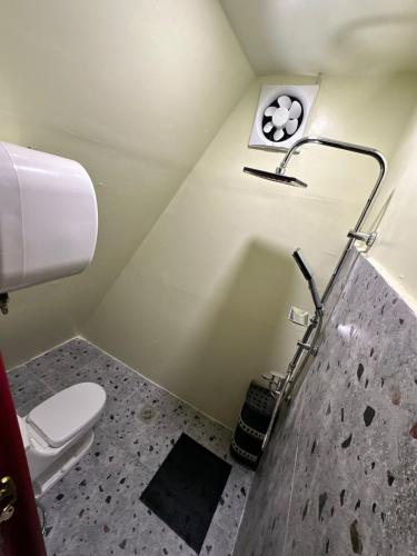 a bathroom with a toilet and a clock on the wall at كوخ بلكونه in Taif