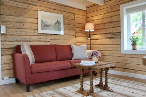 モスケネスにあるExclusive Fishermans cabin in Reineの赤いソファとテーブルのあるリビングルーム