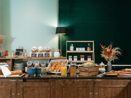 マフリエにあるHotel Novotel Domaine de Maffliers - Paris Val-d'Oiseのカウンターにさまざまな種類の食べ物が並んだビュッフェ