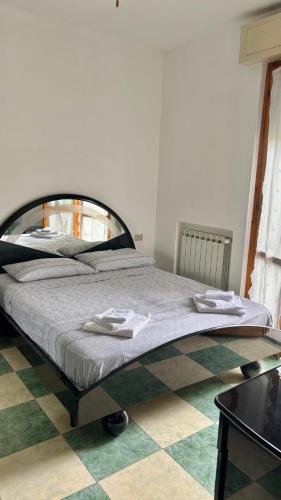 a large bed in a room with a checkered floor at Casa Smeraldo in Ameglia