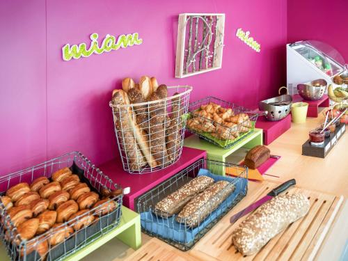 una mesa con cestas de donas y otros pasteles en ibis Styles Besançon, en Besançon