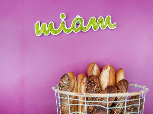 Una cesta de bagels sobre un fondo rosa en ibis Styles Besançon, en Besançon