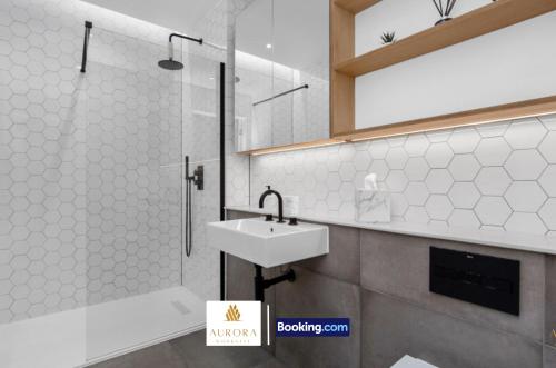 ein Badezimmer mit Waschbecken und Dusche in der Unterkunft Stylish 2BDR Apartment With Cinema, Gym and Free Parking By Aurora WorkNest Short Lets & Serviced Accommodation London in Kew Bridge
