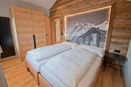 une chambre avec un lit avec un tableau sur le mur dans l'établissement Aletschhorn, Chalet Wiedersehen, à Grächen