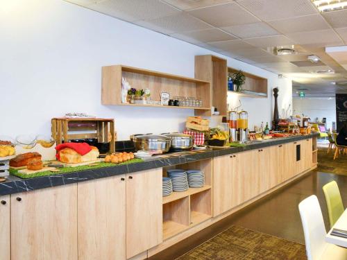 トゥールーズにあるノボテル トゥールーズ ピュルパン アエロポールの食べ物が置かれたカウンターのあるキッチン