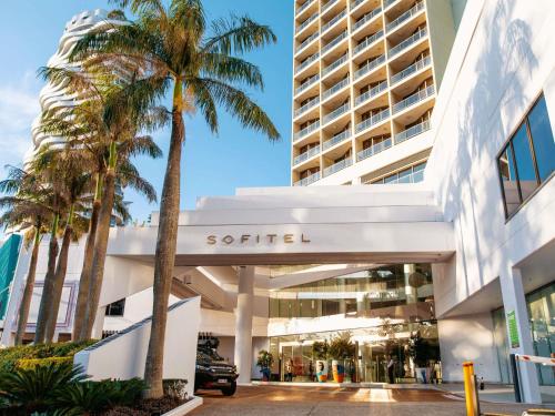 a building with palm trees in front of it at Sofitel Gold Coast Broadbeach in Gold Coast
