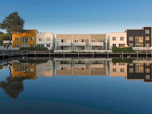 a group of buildings next to a body of water at Islands Maritime Holiday Village Ebeltoft in Ebeltoft