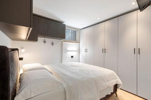 ein Schlafzimmer mit weißen Schränken und einem großen Bett in der Unterkunft Casa Lara e Gaia - Aosta Centro in Aosta