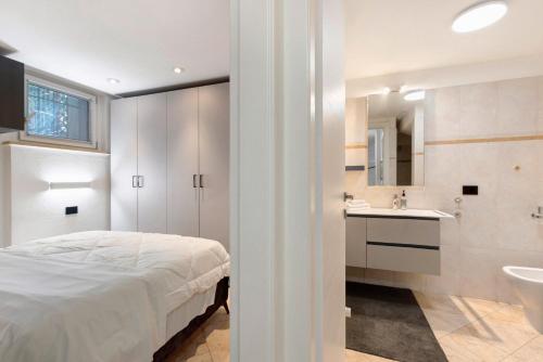 a bedroom with a bed and a bathroom with a sink at Casa Lara e Gaia - Aosta Centro in Aosta