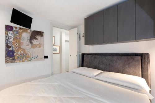 a bedroom with a bed and a painting on the wall at Casa Lara e Gaia - Aosta Centro in Aosta