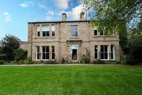 an old brick house with a large grass yard at The Vicarage in Stockton-on-Tees