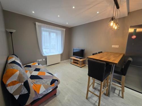 a living room with a couch and a table and a television at Appartement proche Walibi in Les Avenières