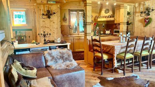 ein Wohnzimmer mit einem Sofa und einem Tisch in der Küche in der Unterkunft Ca' Letizia in San Vito di Cadore