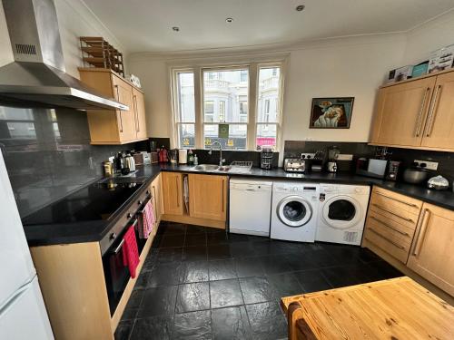 a kitchen with a washer and dryer in it at Luxury Room - St Leonards on Sea - East Sussex in Hollington