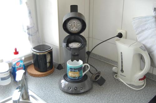una cafetera sentada en un mostrador con una taza en Deichwohnung Strandweg 7, en Friedrichskoog-Spitz
