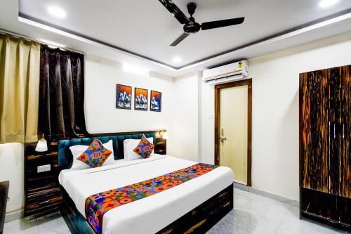 a bedroom with a large bed with colorful pillows at FabHotel O PNR Continental in Hyderabad