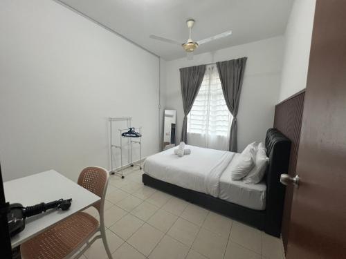 Un dormitorio con una cama y una mesa y una ventana. en Adyan Permata Homestay Ground Floor, en Sandakan