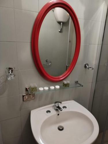 a bathroom with a white sink and a red mirror at Casa vittoria in Sutri