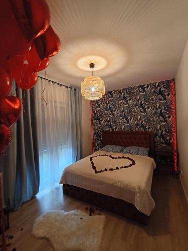 a bedroom with a bed and a chandelier at Apartament Monte Ślęża & Spa in Sobótka