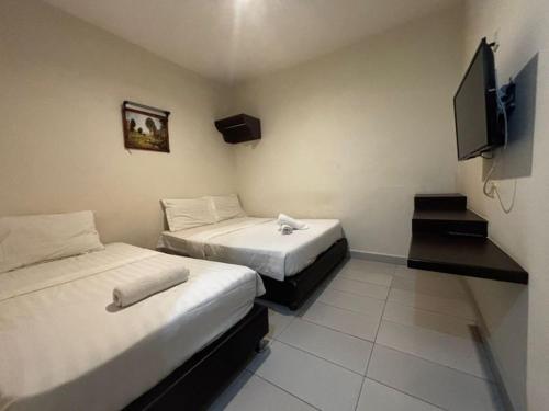 een kamer met 2 bedden en een flatscreen-tv bij JJ Hotel Sitiawan Perak in Sitiawan