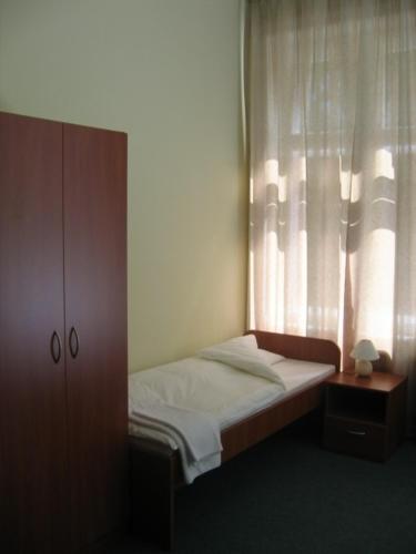 a small bed in a bedroom with a window at Linat Orchim Dom Gościnny in Łódź