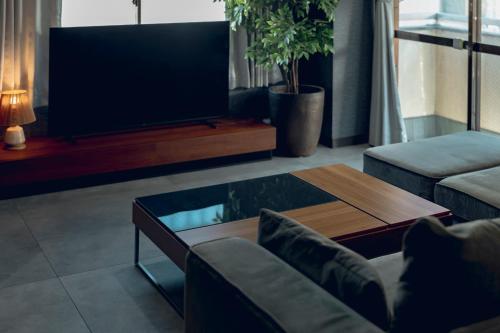 a living room with a tv and a coffee table at ACOE M O R I S H I T A - Direct Access to Tokyo Attractions in Tokyo