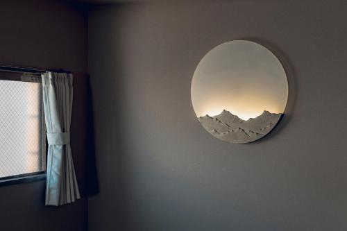 a mirror on a wall with a picture of mountains at ACOE M O R I S H I T A - Direct Access to Tokyo Attractions in Tokyo
