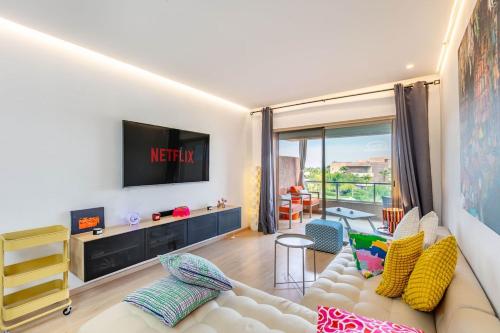 a living room with a couch and a tv at Appartement luxe Prestige Opale Golf in Marrakech