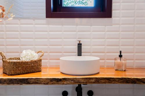 een badkamerbar met een wastafel en een mand erop bij Casa Encosta do Monte in Póvoa de Lanhoso