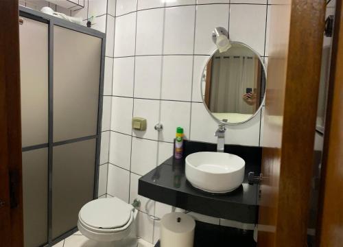 イタペマにあるApartamento Meia Praiaのトイレ、洗面台、鏡のあるバスルーム