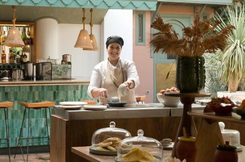 Um homem de pé numa cozinha a preparar comida. em Les Jardins De La Médina em Marraquexe