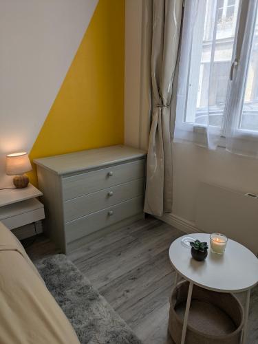 a bedroom with a bed and a table and a window at Appartement RDC Soleil in La Flèche