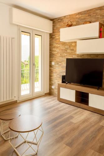 a living room with a television and a table at Casa Perla dei Laghi - Lake View, BBQ, WiFi 1Gb & AirCond in Porlezza