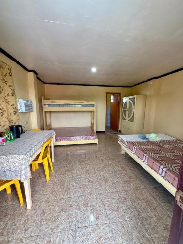 a room with two beds and a table in it at JJL pension house in Siquijor