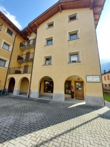 een groot geel gebouw met een bord erop bij Lo chalet di Lucky in Campodolcino