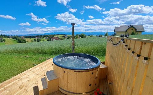 a hot tub on a wooden deck with a water fountain at Kominkowy Zakątek in PyzÃ³wka