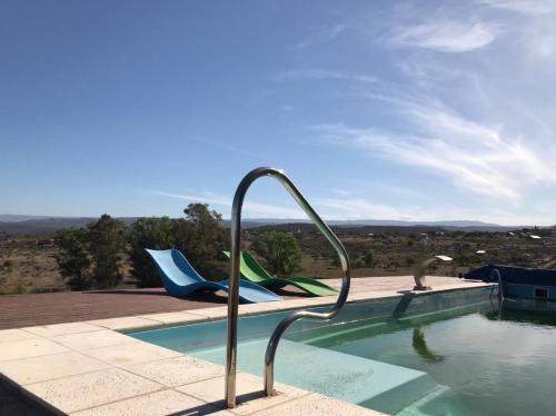 a pool with two lounge chairs next to the water at casa con vista 360 a las montañas y pileta in Tanti