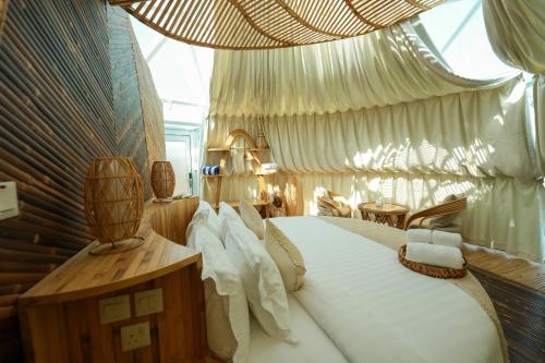 a bedroom with a large bed with a large window at Luxeglamp in Umm Al Quwain