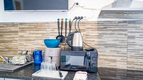 a microwave sitting on top of a kitchen counter at INN Mountain Country House in Caniço