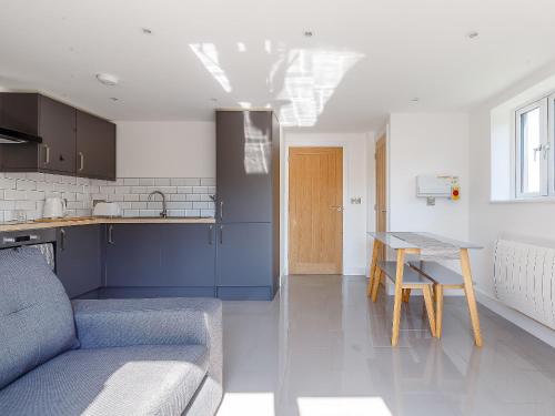 una cucina con un divano e un tavolo in una stanza di Blackberry Cottage a Stowmarket