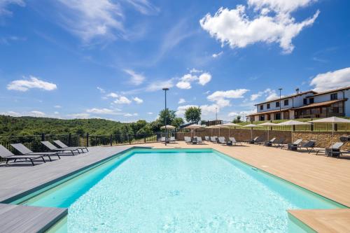 a swimming pool with lounge chairs and a building at Villa Setona by VacaVilla in Bucine