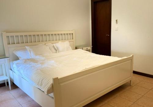 a bedroom with a large bed with white sheets and pillows at High Altitude Makkah - Aziziya Spacious Flat in Makkah